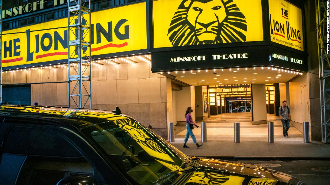 People walk past a closed Broadway theater on March 13 after New York canceled all gatherings over 500 people.